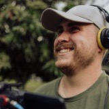 Matt Benn smiling behind a camera monitor on location